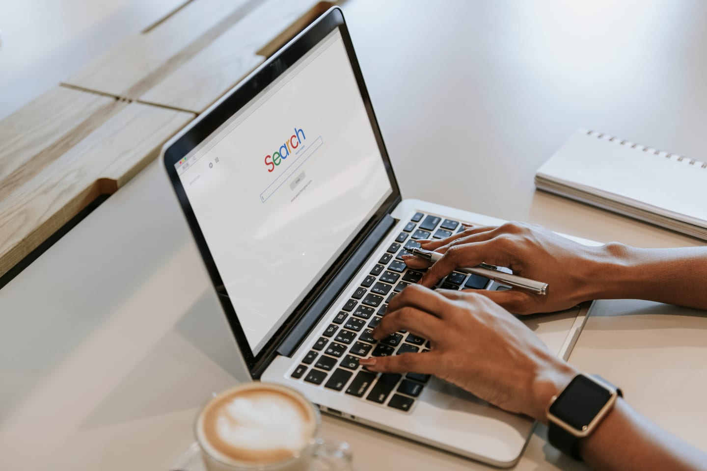 Professional working on a Google Ads campaign for a Cleveland business at a laptop with coffee