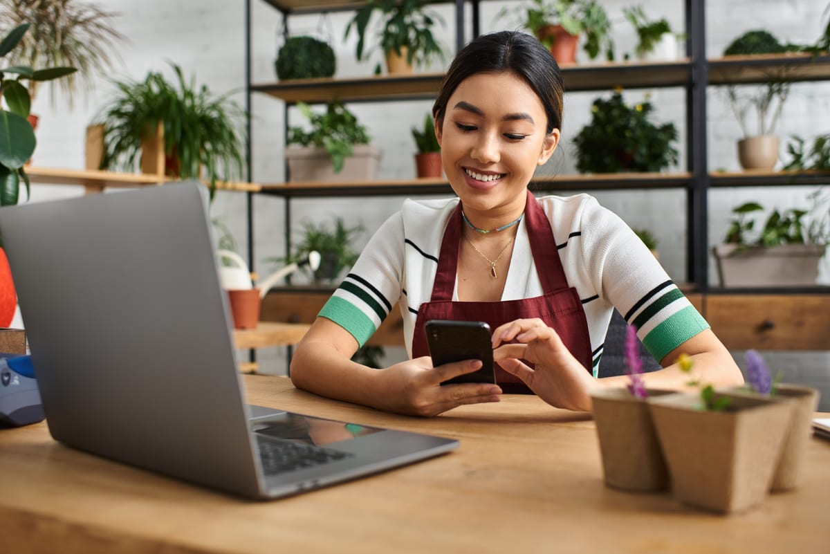 A plant store owner checking Google reviews and their business profile on a smartphone